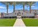 Inviting community entrance with decorative wall, lush green lawn, and towering palm trees creating a grand arrival at 2458 E Lark St, Gilbert, AZ 85297