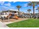 Fun community playground area with shade structure, play equipment, and a glimpse of the neighborhood pool beyond at 2458 E Lark St, Gilbert, AZ 85297