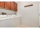 Practical laundry room featuring modern washer and dryer, and upper cabinet storage at 27044 W Escuda Dr, Buckeye, AZ 85396