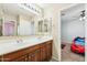 Dual sink bathroom with dark wood vanity and an adjoining bedroom at 2755 E Cowboy Cove Trl, San Tan Valley, AZ 85143