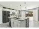 Close-up showcasing a large kitchen island with a sink, stone accents, and ample prep space at 2755 E Cowboy Cove Trl, San Tan Valley, AZ 85143