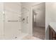 Bathroom with a tiled shower, grab bars, and an open view into the adjacent bedroom at 29065 N Fire Agate Rd, San Tan Valley, AZ 85143