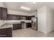 Well-lit kitchen featuring dark wood cabinets, granite countertops, and stainless steel appliances at 29065 N Fire Agate Rd, San Tan Valley, AZ 85143