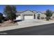 Charming single-story home featuring a gray stucco exterior, a two-car garage, and low maintenance landscaping at 2994 N 305Th Dr, Buckeye, AZ 85396