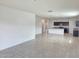 Spacious living room area with neutral tile flooring, white walls, and ample natural light from the kitchen at 2994 N 305Th Dr, Buckeye, AZ 85396