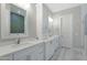 Bright bathroom with double vanity, white cabinetry, framed mirrors, and a tile floor at 3002 W Josiah Trl, Queen Creek, AZ 85144