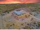 Wide aerial angle of the house sitting on a hill surrounded by desert terrain at 3002 W Josiah Trl, Queen Creek, AZ 85144