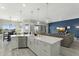 Open-concept kitchen features a large island, a farmhouse sink, and seamless transition to the living area with an accent wall at 3002 W Josiah Trl, Queen Creek, AZ 85144