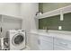 Bright laundry room with white cabinetry, quartz counters, shelves, and modern washer at 3002 W Josiah Trl, Queen Creek, AZ 85144