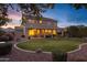 Backyard with a well-kept lawn, covered patio, and landscaping, illuminated at twilight at 3017 S Mesita --, Mesa, AZ 85212