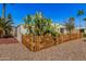 Angle shot of the home's exterior behind a tall cactus and wooden fence at 3104 E Broadway Rd # 276, Mesa, AZ 85204