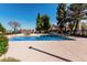 Community pool with lounge chairs, tables, shade trees, and surrounding buildings at 3334 W Morrow Dr # 3, Phoenix, AZ 85027