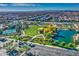 Aerial view of the community featuring lush green spaces, a pool, a lake, and sports courts at 4462 S Frequency Dr, Mesa, AZ 85212