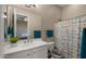 Bright bathroom with a clean white vanity, large mirror, and patterned shower curtain for a fresh, inviting space at 4462 S Frequency Dr, Mesa, AZ 85212