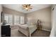 Cozy bedroom featuring a comfortable bed, soft carpeting, plantation shutters, and a ceiling fan at 4462 S Frequency Dr, Mesa, AZ 85212