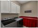 Functional laundry room with modern washer and dryer, white cabinetry, and a practical folding station at 4462 S Frequency Dr, Mesa, AZ 85212