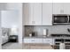 Modern kitchen with stainless steel microwave, white cabinets, and stylish backsplash at 4595 W Stonecrop Dr, San Tan Valley, AZ 85144