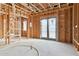 Unfinished living room displaying wood framing, exposed ceiling beams, and a sliding glass door, emphasizing the construction phase at 6001 N 37Th Pl, Paradise Valley, AZ 85253