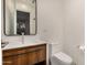 Modern bathroom featuring a wood vanity with a white countertop, large mirror, and toilet at 7047 E Earll Dr # 1002, Scottsdale, AZ 85251