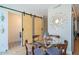 Dining area showcasing sliding barn doors leading to a bathroom, decorative wall art, and hardwood floors at 7047 E Earll Dr # 1002, Scottsdale, AZ 85251