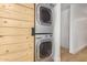 Laundry area with stacked washer and dryer behind a sliding wooden door at 7047 E Earll Dr # 1002, Scottsdale, AZ 85251