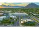 Aerial view of a commercial area featuring modern buildings, lush green trees, and a mountain in the background at 7121 E Rancho Vista Dr # 2002, Scottsdale, AZ 85251