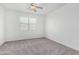 Carpeted bedroom featuring neutral walls, a ceiling fan, and a large window at 7234 E Eagle Nest Way, San Tan Valley, AZ 85143