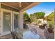 Outdoor patio with glass top table, seating area, and lush backyard view at 7282 E Del Acero Dr, Scottsdale, AZ 85258