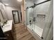 Modern bathroom with marble tile, dual sinks, and a glass-enclosed shower-tub at 8833 N 39Th Ave, Phoenix, AZ 85051