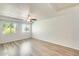 Spacious bedroom featuring a ceiling fan, two windows, wood floors, and white brick walls at 920 N 82Nd N St # H203, Scottsdale, AZ 85257