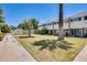 Exterior view of well-maintained townhomes with green lawn, sidewalk and mature trees at 920 N 82Nd N St # H203, Scottsdale, AZ 85257