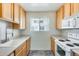 Cozy kitchen with white appliances, wood cabinets, tile floors and a window for natural light at 920 N 82Nd N St # H203, Scottsdale, AZ 85257