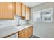 Bright kitchen with white sink and faucet, wood cabinets and stainless steel dishwasher at 920 N 82Nd N St # H203, Scottsdale, AZ 85257