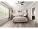 Inviting main bedroom featuring a tray ceiling, wood floors, and neutral decor for a relaxing ambiance at 10131 W El Cortez Pl, Peoria, AZ 85383