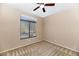 This cozy bedroom offers comfortable carpet, a ceiling fan, and a large window to maximize natural light at 1054 S Butte Ln, Gilbert, AZ 85296