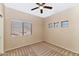 Comfortable carpet, a ceiling fan, and a window with backyard views define this bedroom at 1054 S Butte Ln, Gilbert, AZ 85296