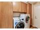 Convenient laundry room with wood cabinets, lots of storage and a new, modern washer and dryer set at 1054 S Butte Ln, Gilbert, AZ 85296