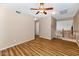 A spacious living room with wood floors, a ceiling fan, and an adjacent staircase at 1054 S Butte Ln, Gilbert, AZ 85296