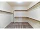 Spacious walk-in closet with carpet flooring and custom wood shelving and hanging rods for ample storage space at 1054 S Butte Ln, Gilbert, AZ 85296