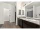 Bathroom with double vanity, white walls, and hardwood flooring at 11509 W Boca Raton Rd, El Mirage, AZ 85335