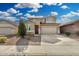 Two-story home featuring a desert landscape, paver driveway, and a two-car garage at 11509 W Boca Raton Rd, El Mirage, AZ 85335