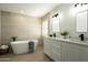 Bathroom featuring a soaking tub, dual sink vanity and modern lighting at 120 W Thunderbird Rd, Phoenix, AZ 85023