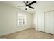 Bright bedroom featuring wood floors, a modern fan, and a closet with sliding doors at 120 W Thunderbird Rd, Phoenix, AZ 85023