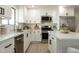 This updated kitchen features stainless appliances, white cabinets and stone countertops at 120 W Thunderbird Rd, Phoenix, AZ 85023