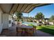 Covered patio with outdoor seating, overlooking a pool and spacious backyard with manicured landscaping at 120 W Thunderbird Rd, Phoenix, AZ 85023