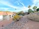 Well-manicured backyard with desert landscaping, mature foliage, palm trees, and stunning blue skies at 14236 N 28Th St, Phoenix, AZ 85032