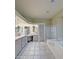 Luxury bathroom with dual vanities, tile flooring, glass shower and separate soaking tub at 14236 N 28Th St, Phoenix, AZ 85032