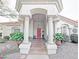 Inviting front porch featuring white columns, a red door, decorative plants, and charming accents at 14236 N 28Th St, Phoenix, AZ 85032