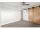 This bedroom includes carpet, a ceiling fan, and a closet with natural wood sliding doors at 14608 N Montego Ct, Phoenix, AZ 85053