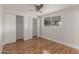 Bright bedroom featuring hardwood floors, a ceiling fan, a window, and closet space at 14608 N Montego Ct, Phoenix, AZ 85053